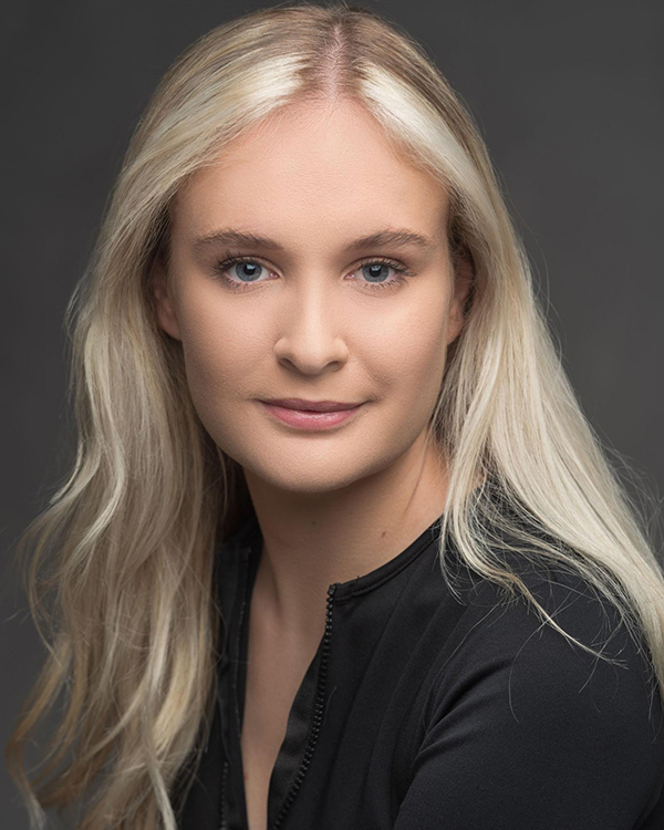 Studio headshot of Katie-Victoria-Turner wearing a black top against a dark grey backround